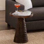 Dark wooden end and side table with a round top and hand-carved conical base in natural Sheesham wood.
