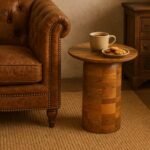 Round mango wood side table with natural finish and smooth cylindrical pedestal base.