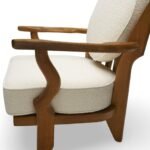Handcrafted solid wood lounge chair with artistic backrest and circular cushioned seat in cream upholstery – luxury designer accent chair