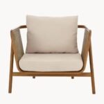 Rattan armchair with solid wood frame, cane sides and beige upholstered cushion