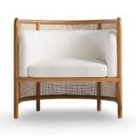 Tejasvi rattan lounge chair with curved cane sides and upholstered seat