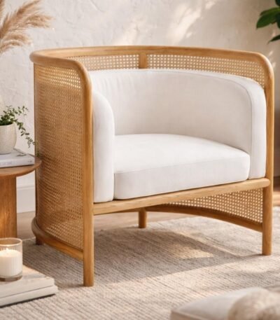 Tejasvi rattan lounge chair with curved cane sides and upholstered seat
