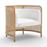 Tejasvi rattan lounge chair with curved cane sides and upholstered seat