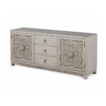 Hand carved TV unit in distressed beige finish crafted from solid mango wood with floral carved cabinet doors and storage drawers.