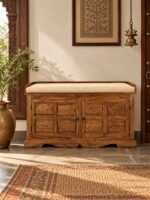 Sheesham Wood Storage Bench with elephant-carved wooden doors, hidden shoe storage and beige cushioned seat in honey finish.