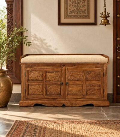 Sheesham Wood Storage Bench with elephant-carved wooden doors, hidden shoe storage and beige cushioned seat in honey finish.