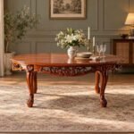 Floravelle Carved Teakwood Dining Table with oval tabletop, intricate floral apron, cabriole legs and natural wood finish.
