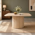 Flutera natural oak fluted dining table with rounded square tabletop, vertical ribbed cylindrical pedestal and light ivory wood finish.