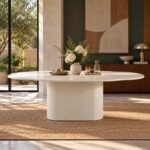 Lunelle white concrete effect wood dining table with oval tabletop, rounded edges and sculptural central pedestal base.