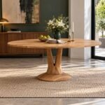 Solstice Grove solid acacia wood oval pedestal dining table with natural finish, 220 cm tabletop, sculptural wooden supports and circular base.