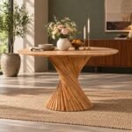 Twistwood acacia wood twisted pedestal dining table with natural round tabletop and sculptural hourglass base made from diagonal wooden slats.